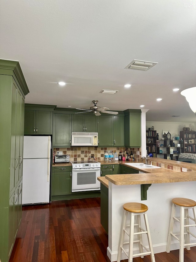 kitchen featuring green cabinetry, kitchen peninsula, white appliances, and dark hardwood / wood-style floors