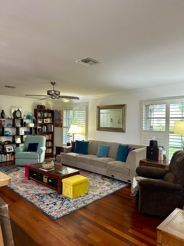 living room featuring hardwood / wood-style floors, ceiling fan, and crown molding