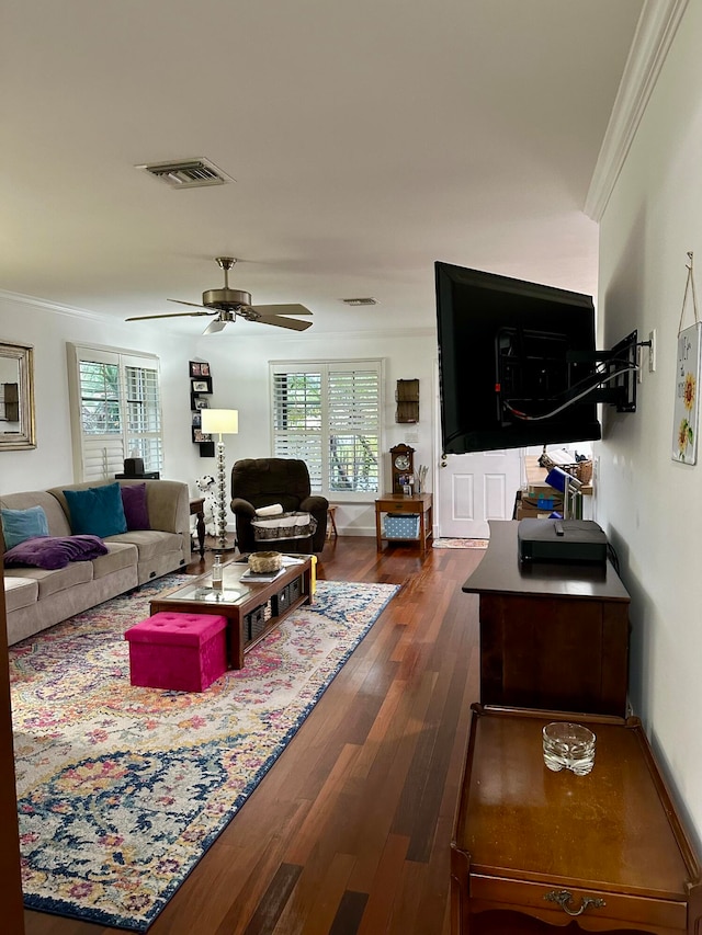 living room with dark hardwood / wood-style flooring, a wealth of natural light, and ornamental molding