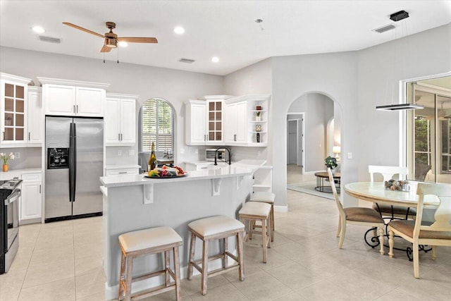 kitchen featuring white cabinetry, sink, kitchen peninsula, a kitchen bar, and appliances with stainless steel finishes