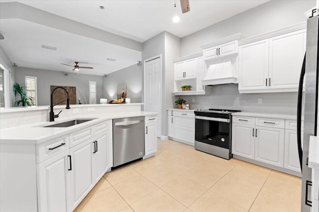 kitchen with white cabinets, light tile patterned floors, stainless steel appliances, and sink