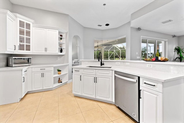 kitchen featuring appliances with stainless steel finishes, light stone counters, sink, white cabinets, and light tile patterned flooring