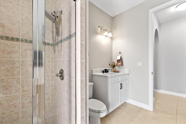 bathroom featuring vanity, a shower with door, tile patterned floors, toilet, and a textured ceiling