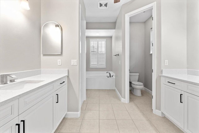 bathroom with tile patterned flooring, vanity, toilet, and a bathtub