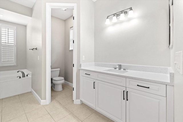 bathroom featuring tile patterned floors, vanity, toilet, and a tub