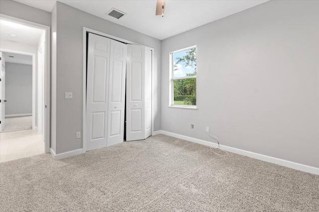 unfurnished bedroom featuring carpet floors, a closet, and ceiling fan