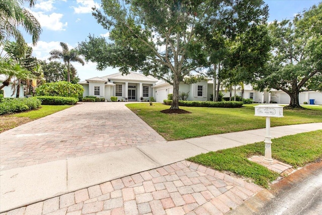 ranch-style home with a front lawn and a garage