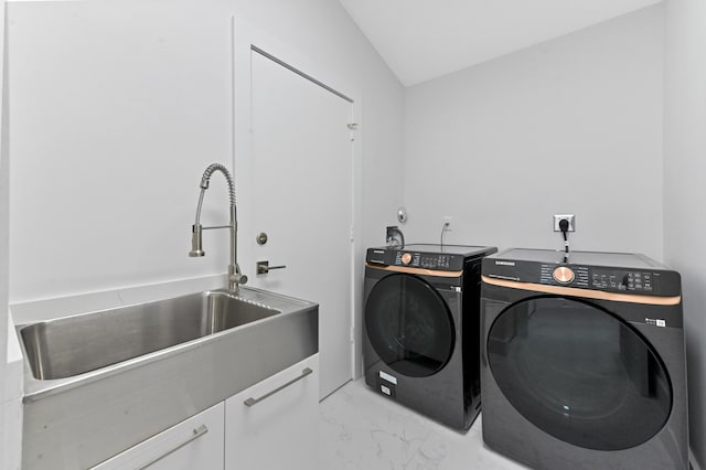 washroom featuring washing machine and clothes dryer, cabinets, and sink