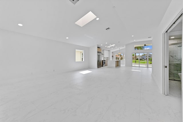 unfurnished living room featuring a skylight