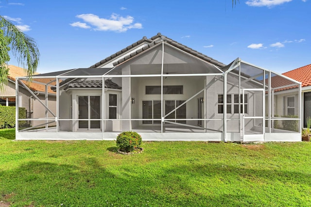 rear view of house with a lawn and a lanai