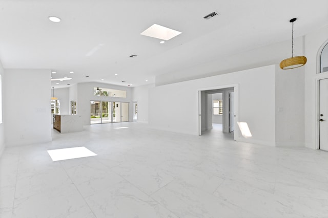 unfurnished living room with a skylight