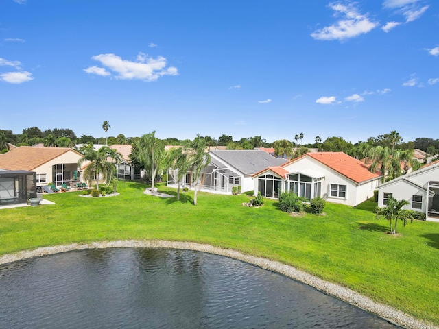 rear view of property with a yard and a water view