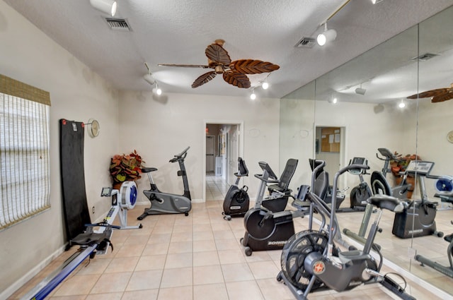 exercise room featuring a textured ceiling, track lighting, and ceiling fan