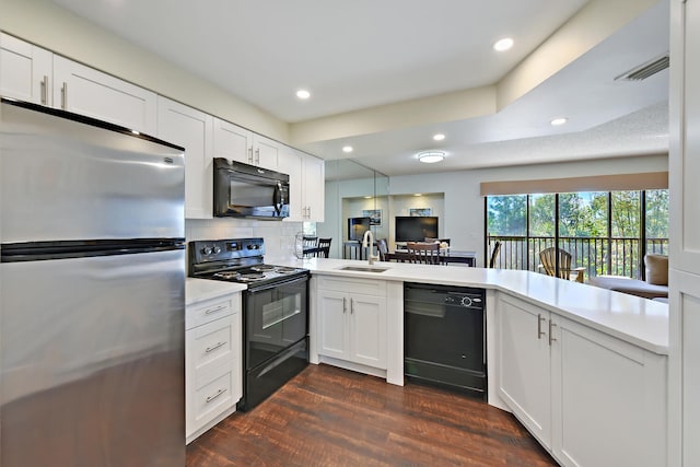 kitchen with black appliances, white cabinets, kitchen peninsula, and dark wood-type flooring