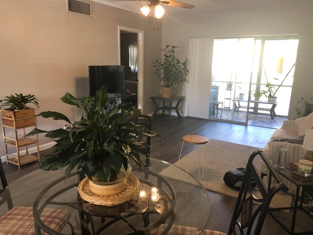 living room featuring ceiling fan and dark hardwood / wood-style flooring