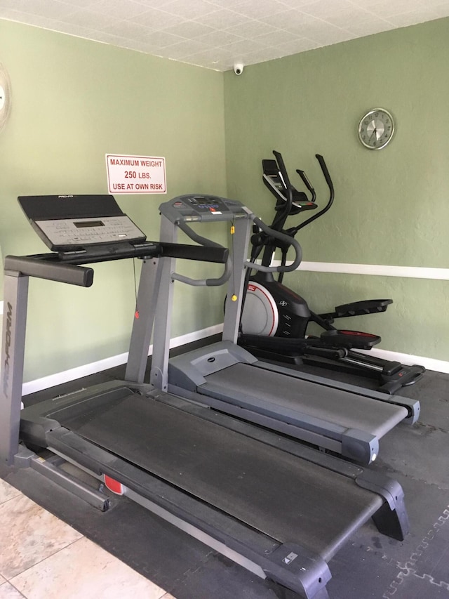 workout area featuring tile patterned flooring