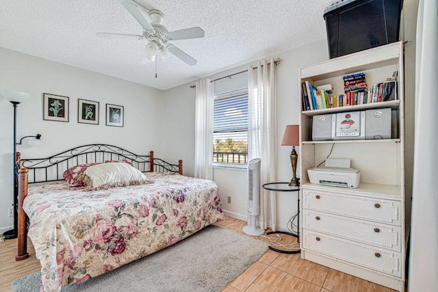 bedroom with ceiling fan, a textured ceiling, and light hardwood / wood-style flooring