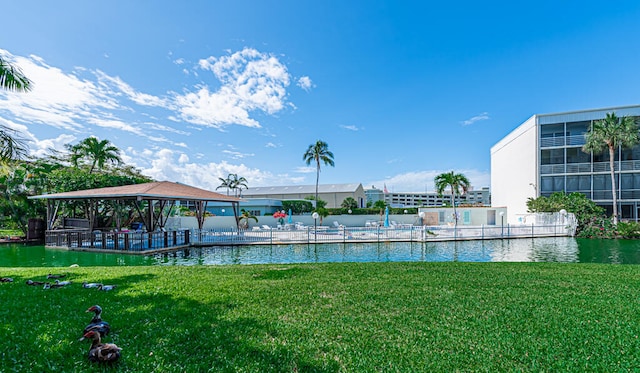 view of swimming pool featuring a water view and a yard