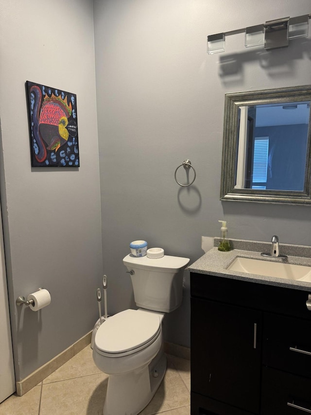 bathroom with toilet, vanity, and tile patterned floors