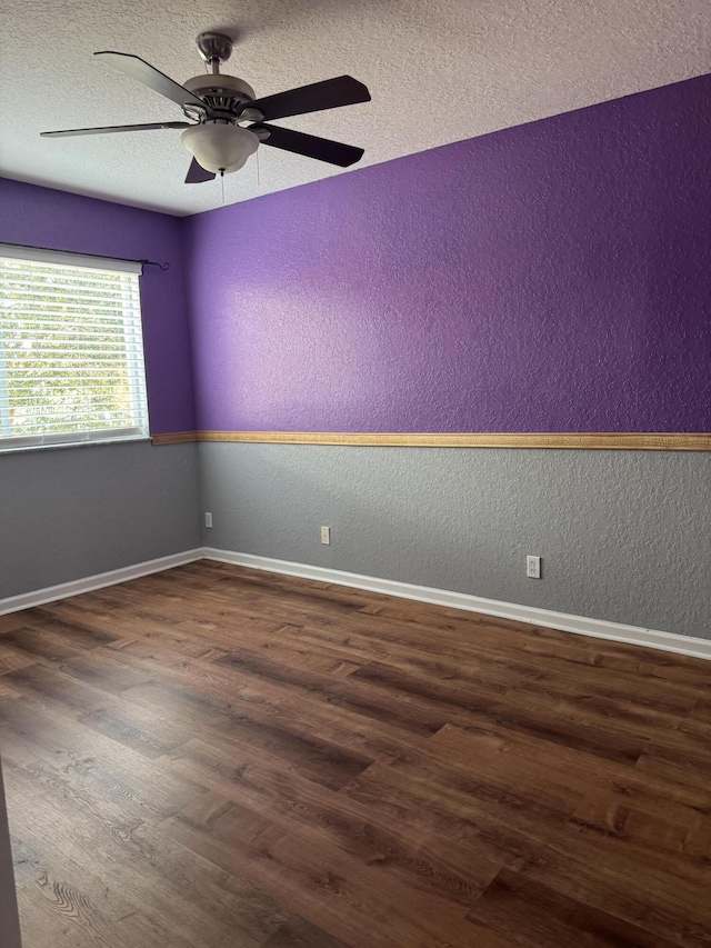 spare room featuring a textured ceiling, ceiling fan, and dark wood-type flooring