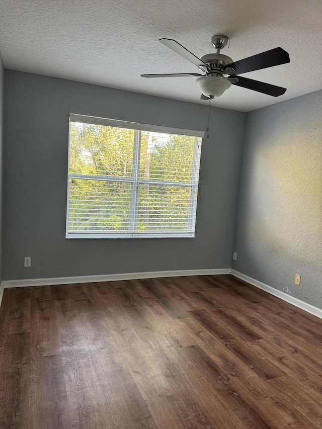 empty room featuring ceiling fan, dark hardwood / wood-style flooring, and a textured ceiling