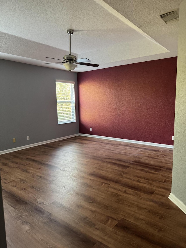 spare room with dark hardwood / wood-style flooring, a textured ceiling, and ceiling fan