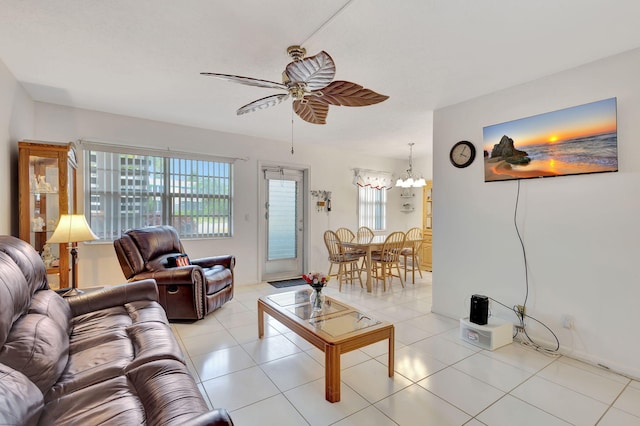 tiled living room featuring ceiling fan with notable chandelier