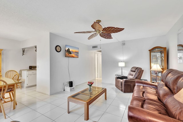 tiled living room with a textured ceiling and ceiling fan