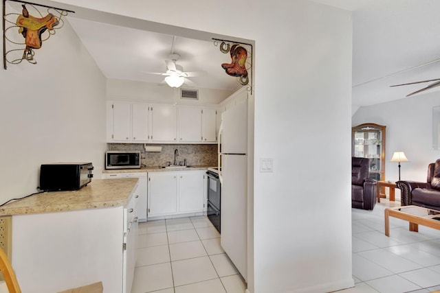 kitchen with white cabinetry, sink, tasteful backsplash, black / electric stove, and white fridge