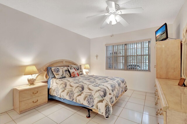 tiled bedroom with a textured ceiling and ceiling fan