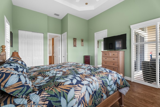 bedroom with dark hardwood / wood-style flooring, ceiling fan, and a closet