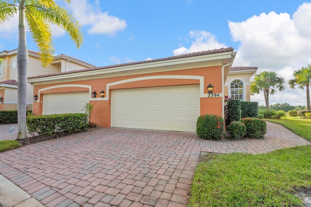 mediterranean / spanish-style home with a front lawn and a garage