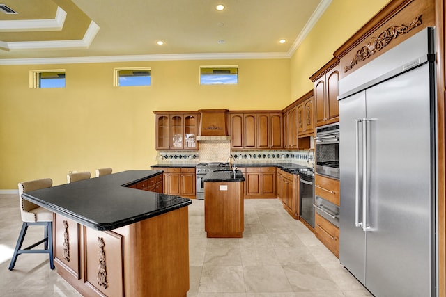 kitchen featuring ornamental molding, a kitchen breakfast bar, premium appliances, and a kitchen island