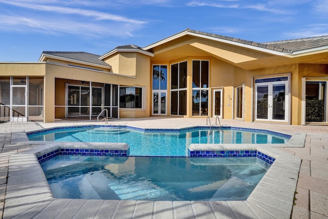 view of pool with a sunroom, an in ground hot tub, french doors, and a patio area