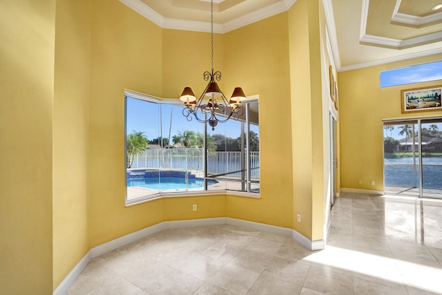 unfurnished room featuring ornamental molding, a water view, and a chandelier