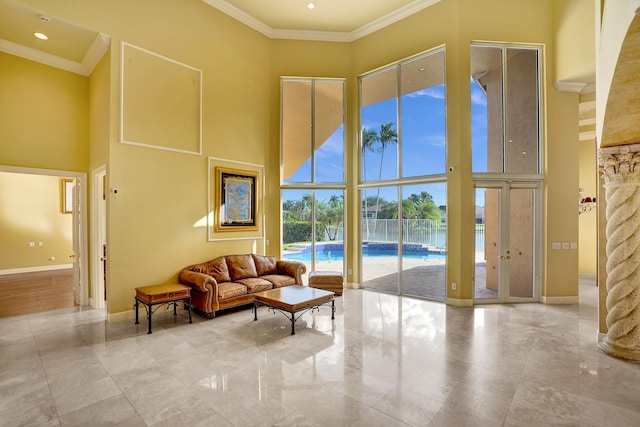 living room with a high ceiling and crown molding