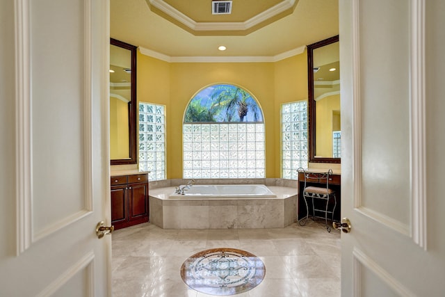 bathroom featuring vanity, crown molding, and tiled tub