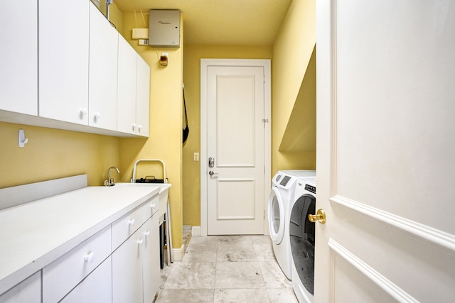 laundry area featuring separate washer and dryer and cabinets