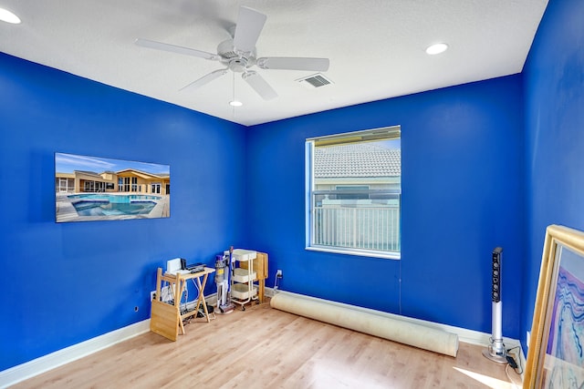 interior space featuring hardwood / wood-style flooring, ceiling fan, and a textured ceiling