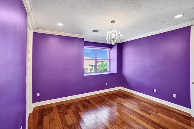 spare room with hardwood / wood-style floors, a notable chandelier, and a textured ceiling