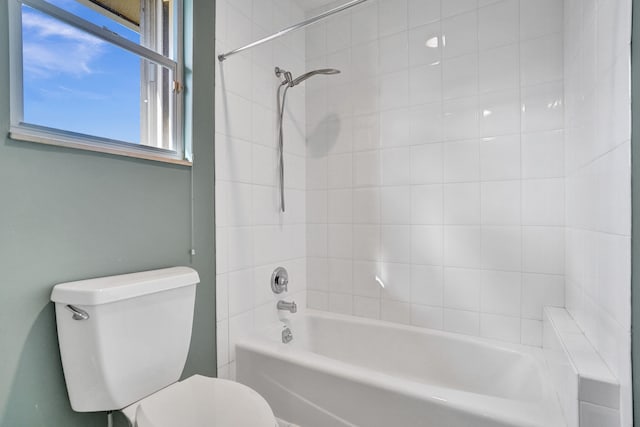 bathroom featuring tiled shower / bath and toilet