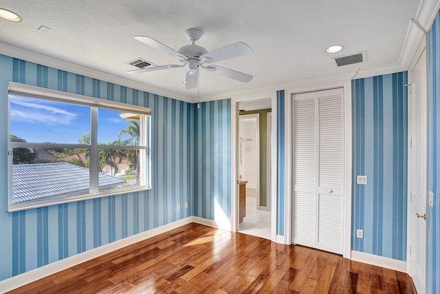 unfurnished bedroom featuring hardwood / wood-style flooring, ceiling fan, and a textured ceiling