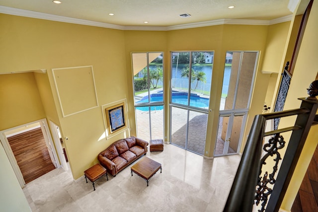 living room featuring light hardwood / wood-style flooring, a water view, and crown molding