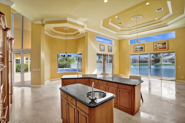 kitchen featuring a water view, decorative light fixtures, crown molding, and a center island