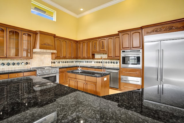 kitchen with premium appliances, tasteful backsplash, custom range hood, a high ceiling, and dark stone countertops