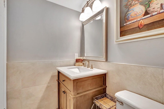 bathroom with tile walls, vanity, and toilet