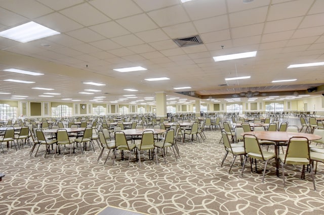 dining area featuring light colored carpet and a drop ceiling