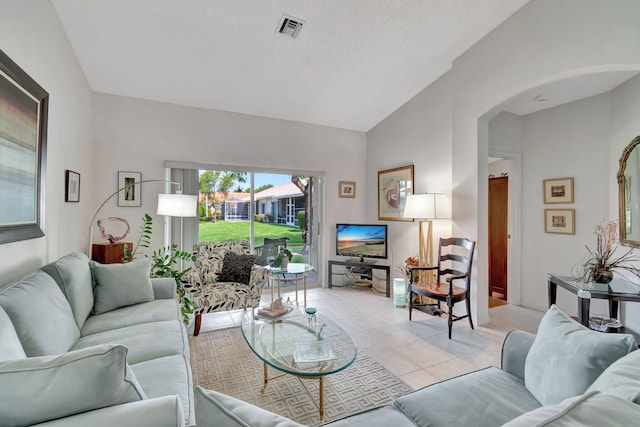 tiled living room featuring vaulted ceiling