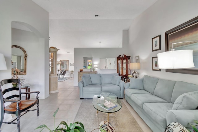 living room with lofted ceiling and light tile patterned floors