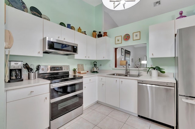 kitchen featuring white cabinetry, sink, stainless steel appliances, high vaulted ceiling, and light tile patterned floors